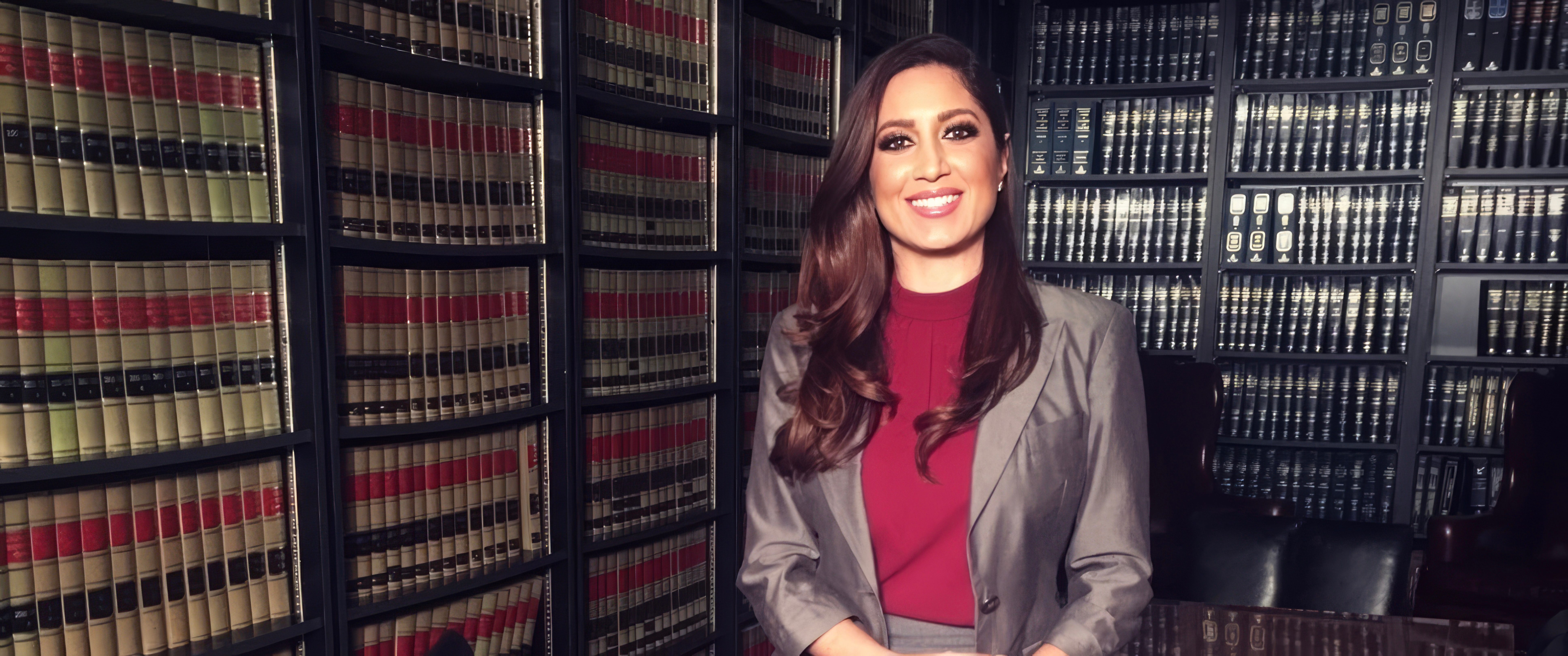 Anahita Sedaghatfar standing in a law library surrounded by case reporters